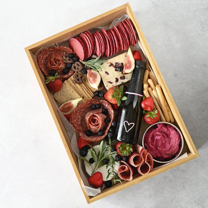 Bamboo grazing box with clear lid with a selection of meats and cheeses inside