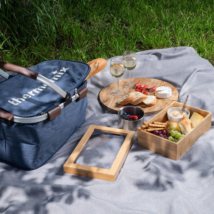 Picnic settings with bamboo grazing box with fresh fruits and cheeses